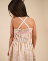 Early Sunday, Alisson Dress in butterfly print color, made from printed cotton tiny swiss dobby fabric, featuring smocked bodice, adjustable shoulder straps, sweet tassel accents, and a flowy gathered skirt, shown in a back view of model wearing it.