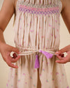 Early Sunday, Alisson Dress in butterfly print color, made from printed cotton tiny swiss dobby fabric, featuring smocked bodice, adjustable shoulder straps, sweet tassel accents, and a flowy gathered skirt, shown in a close up shot of model wearing it.
