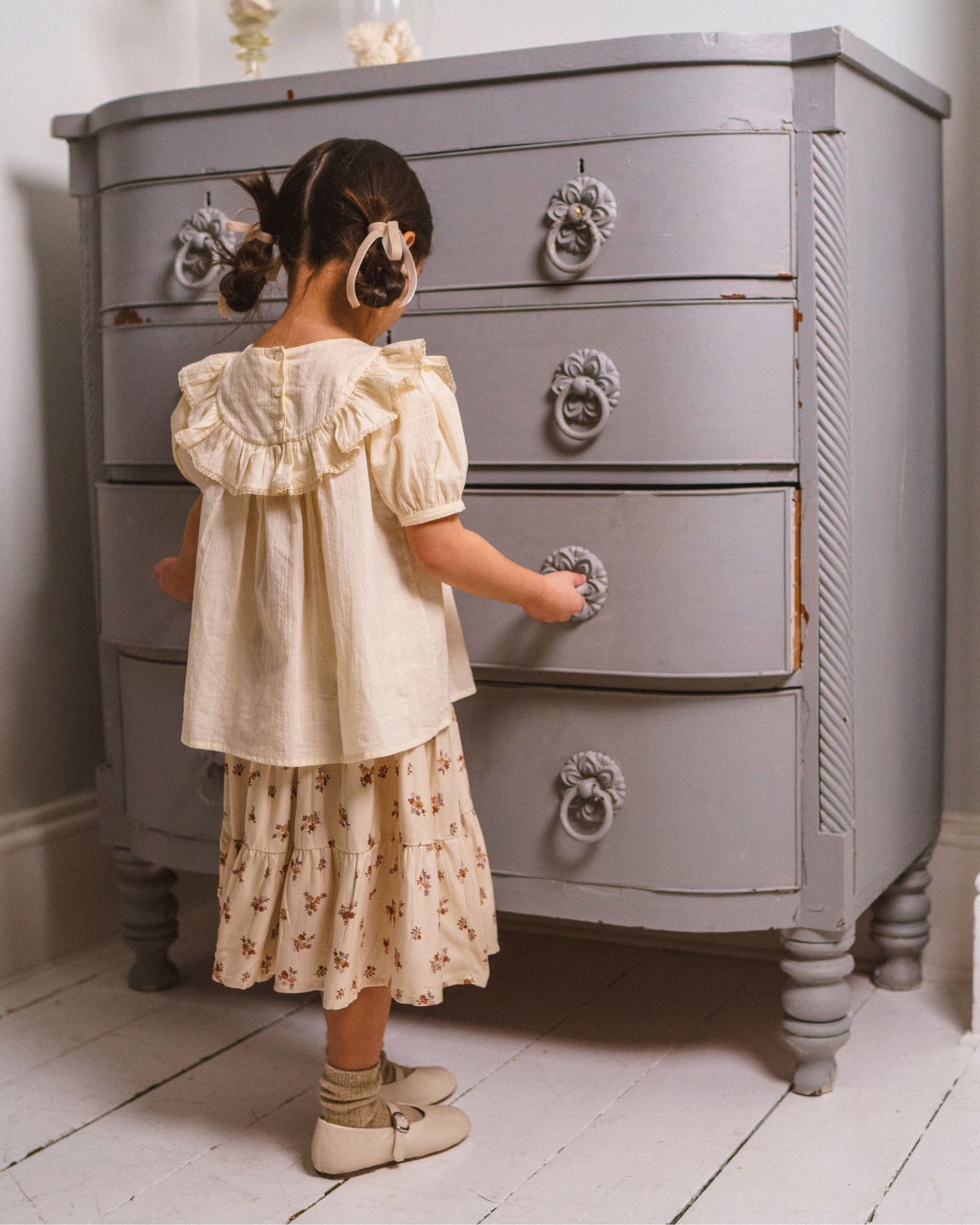 Early Sunday, Amelia Blouse in Hazelnut Cream, made from Dyed Cotton Swiss Dobby Tiny Dots fabric, featuring Classic pleats that enhance the fit and finish, shown in a back view of model wearing