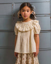 Early Sunday, Amelia Blouse in Hazelnut Cream, made from Dyed Cotton Swiss Dobby Tiny Dots fabric, featuring Classic pleats that enhance the fit and finish, shown in a front view of model wearing it