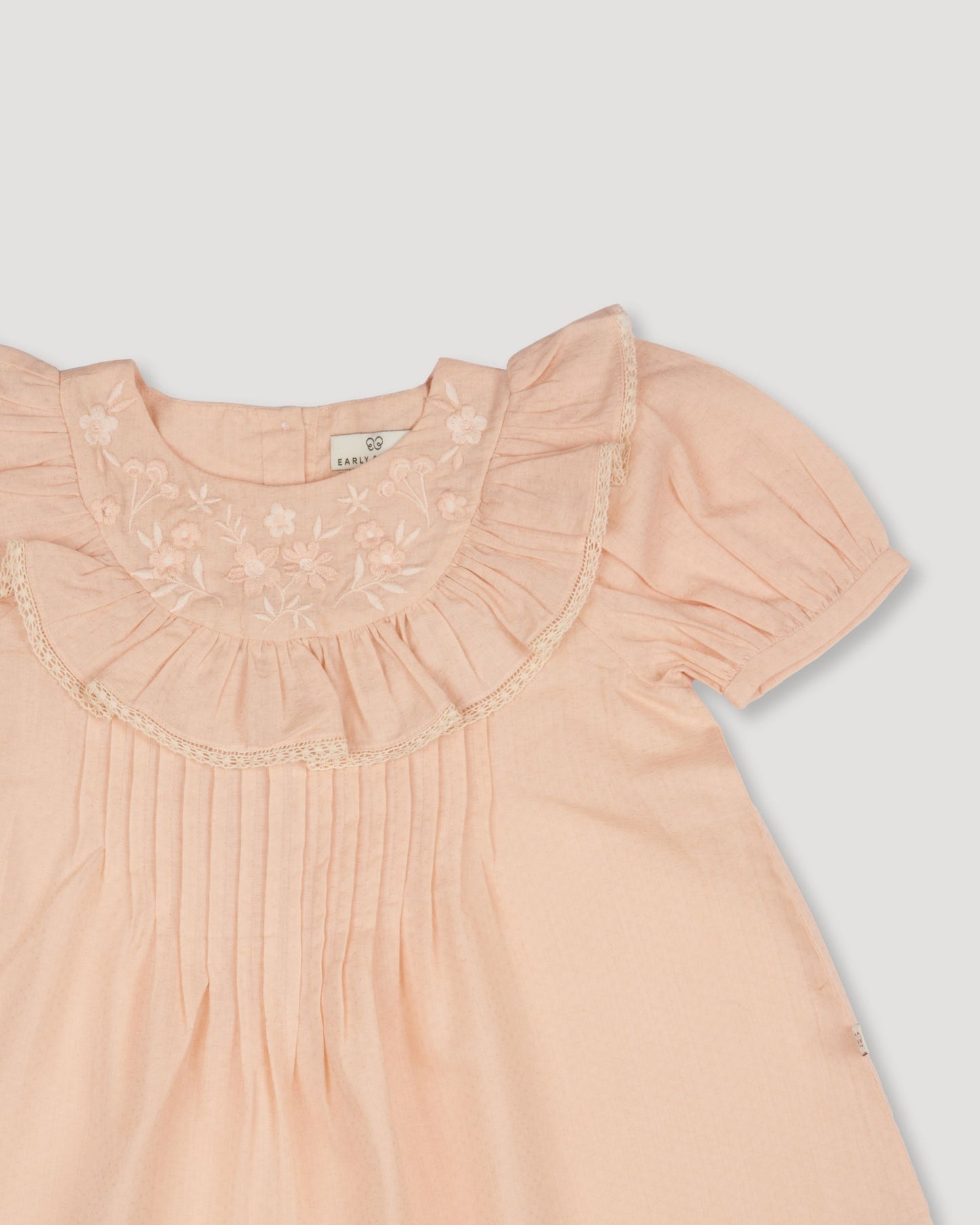 Early Sunday, Amelia Blouse in Nude, made from Dyed Cotton Swiss Dobby Tiny Dots fabric, featuring Classic pleats that enhance the fit and finish, shown in a closeup flat-lay view