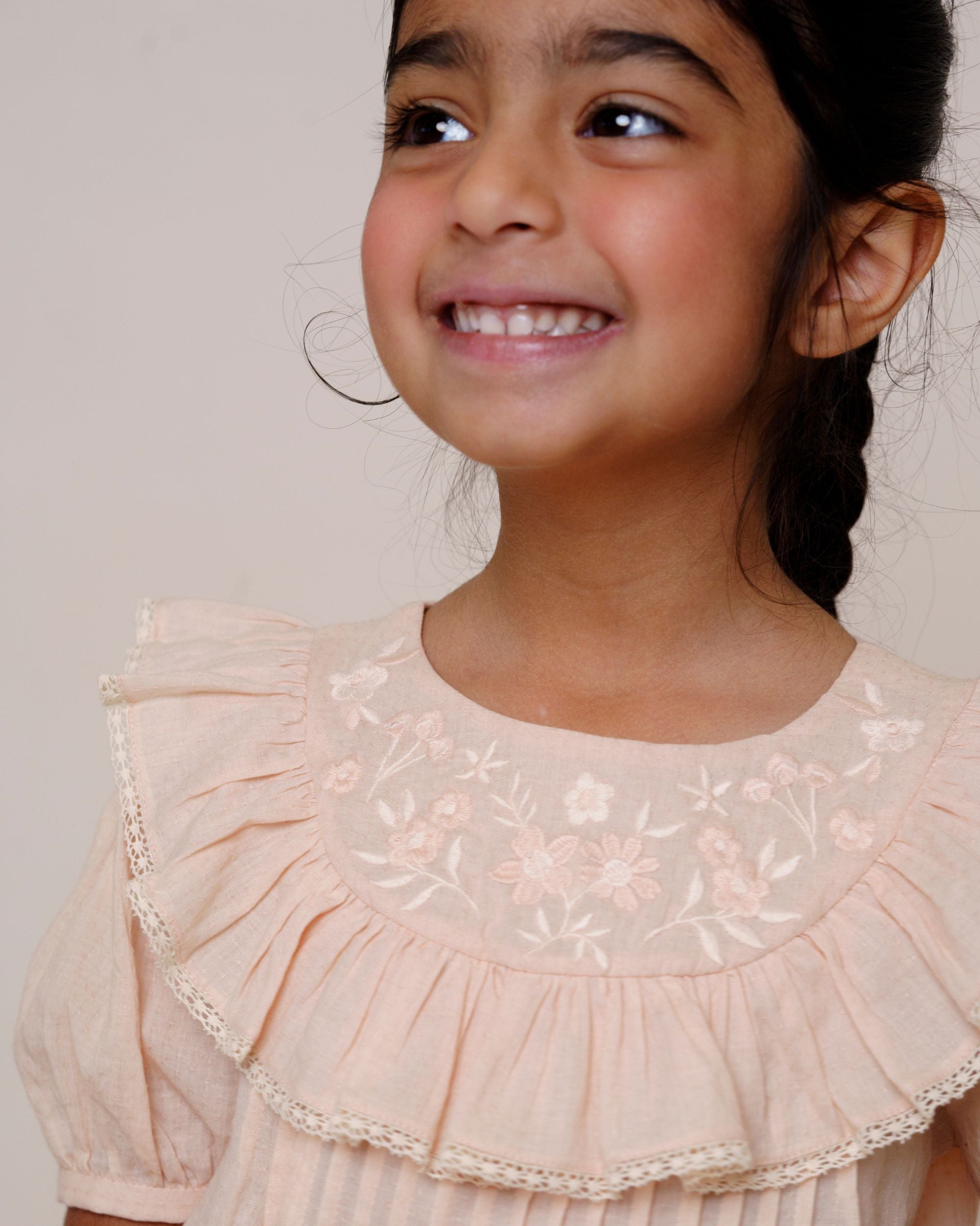 Early Sunday, Amelia Blouse in Nude, made from Dyed Cotton Swiss Dobby Tiny Dots fabric, featuring Classic pleats that enhance the fit and finish, shown in a close-up shot of a model wearing it during a studio shoot