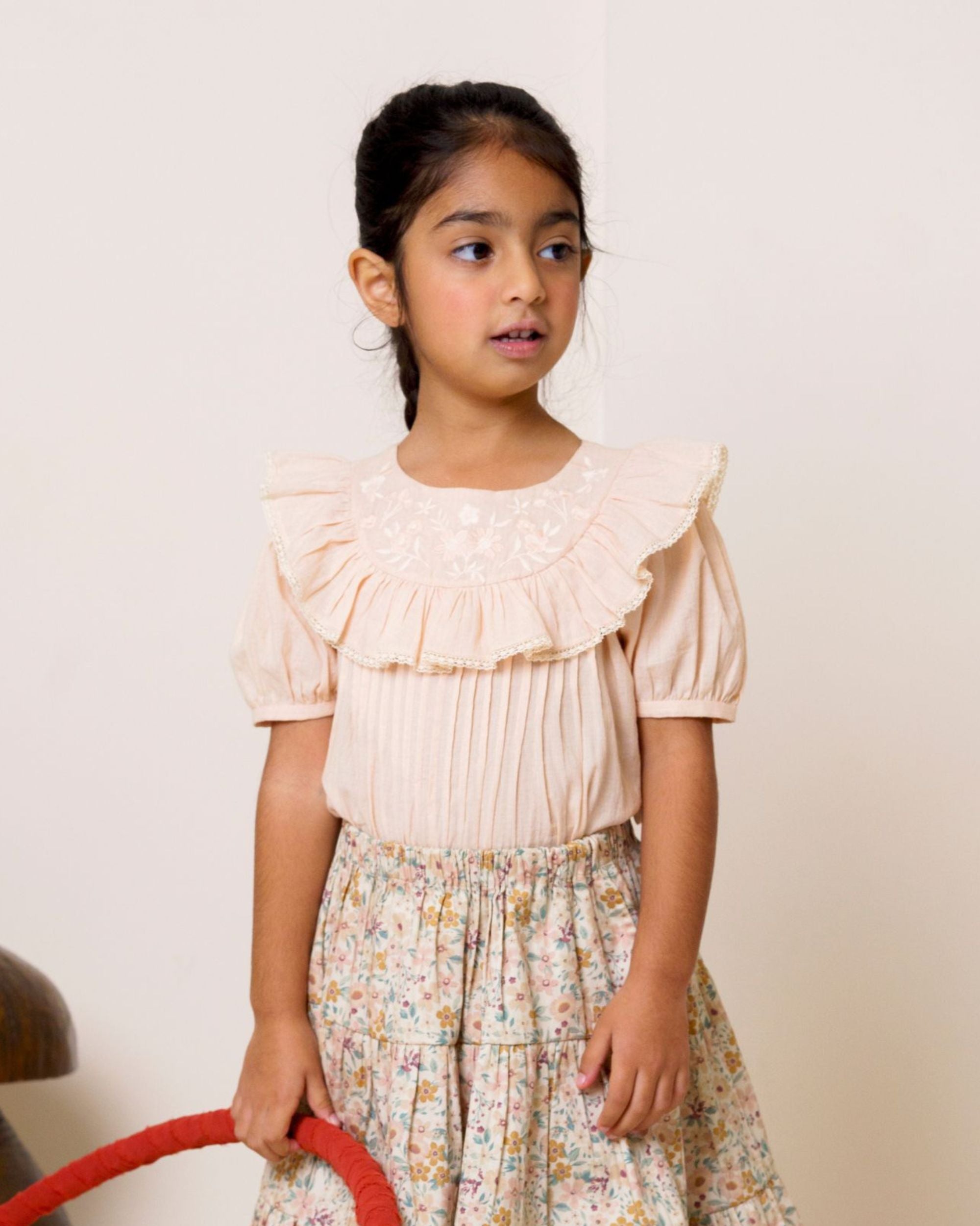 Early Sunday, Amelia Blouse in Nude, made from Dyed Cotton Swiss Dobby Tiny Dots fabric, featuring Classic pleats that enhance the fit and finish, shown in a front view of model wearing it
