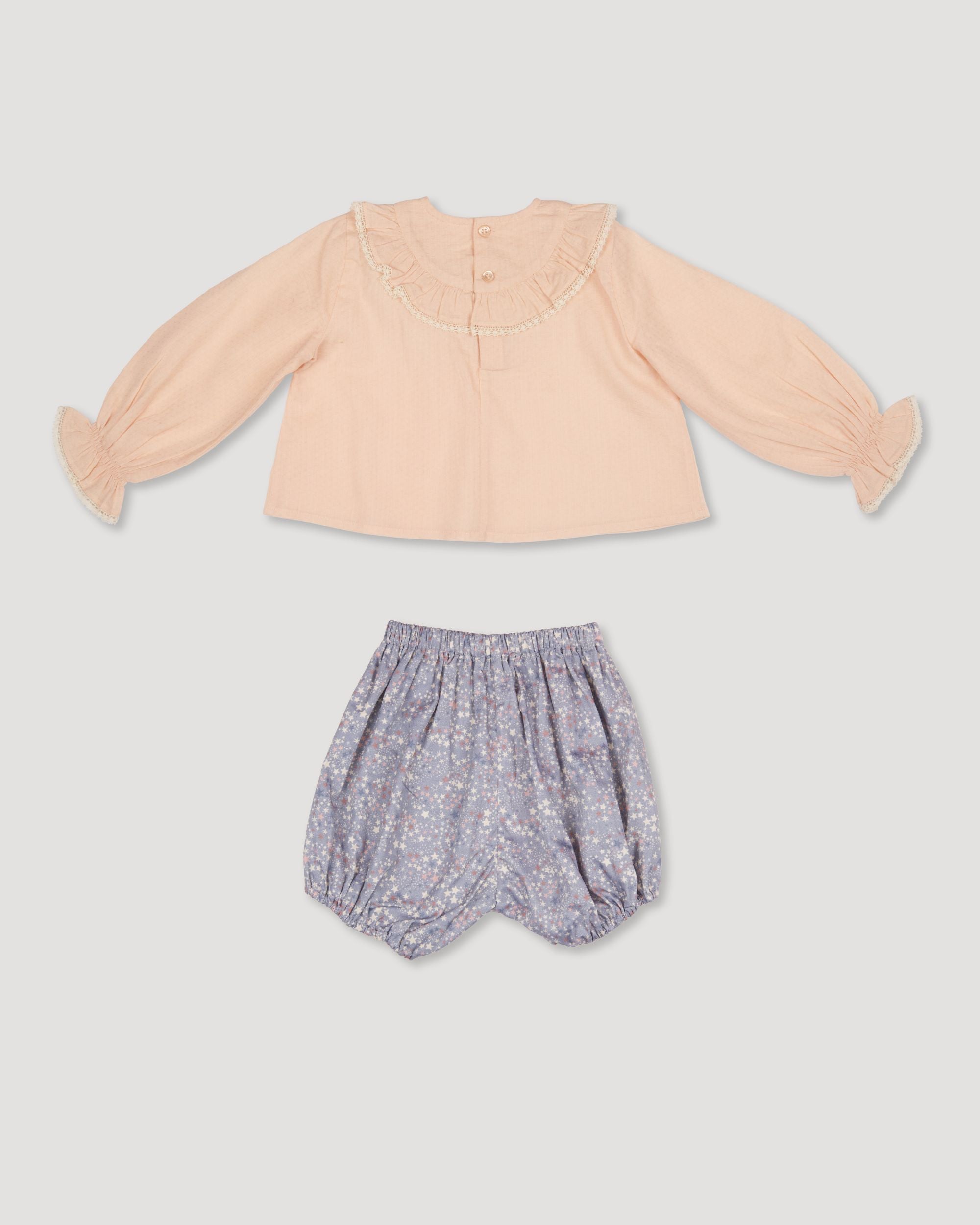 Early Sunday, Amy Baby Blouse & Bloomer Set in Nude & Celestial print, made from Dyed Cotton Swiss Dobby Tiny Dots fabric, featuring a delicate embroidery & lace-trimmed ruffles with elasticated bloomers, shown in a back flat-lay view