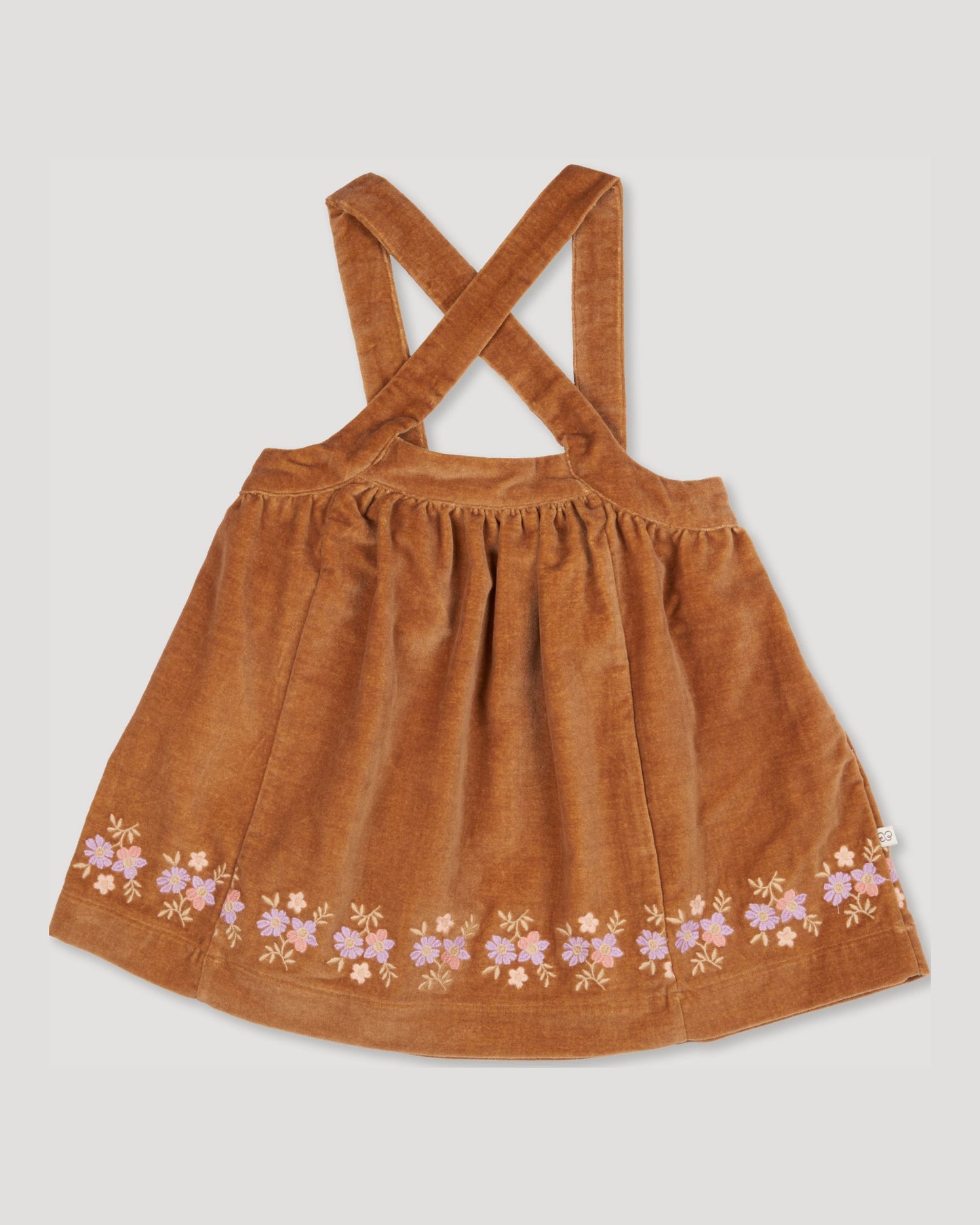 Early Sunday, Anni Skirt in Almond, made from Dyed Cotton Velvet fabric, featuring Delicate floral embroidery along the hem with playful cross-back straps, shown in a front flat-lay view