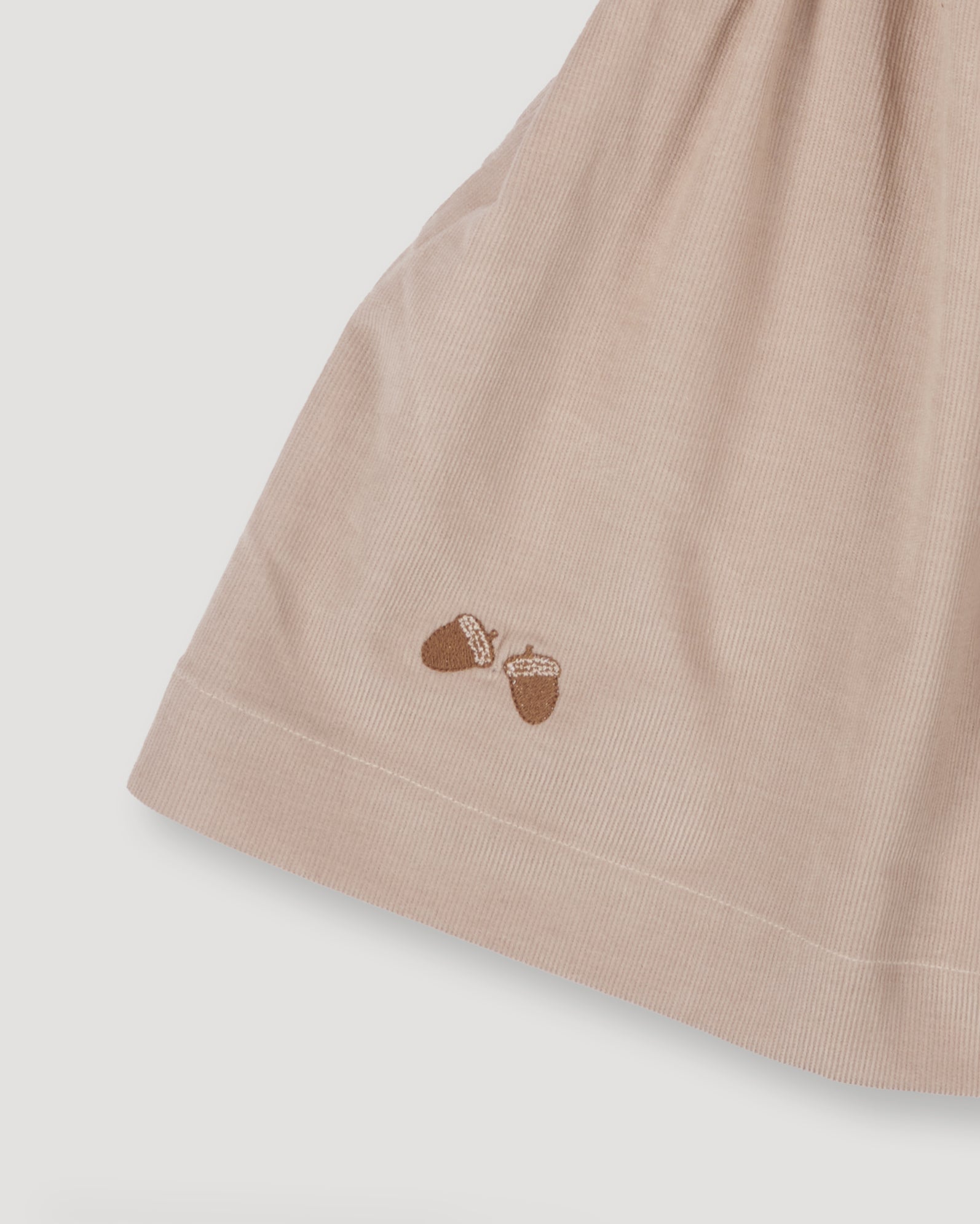 Early Sunday, Annie Skirt in Beige color, made from Cotton Corduroy fabric, featuring a relaxed fit with an elastic waistband & beautiful embroidery, shown in a close-up shot of the print