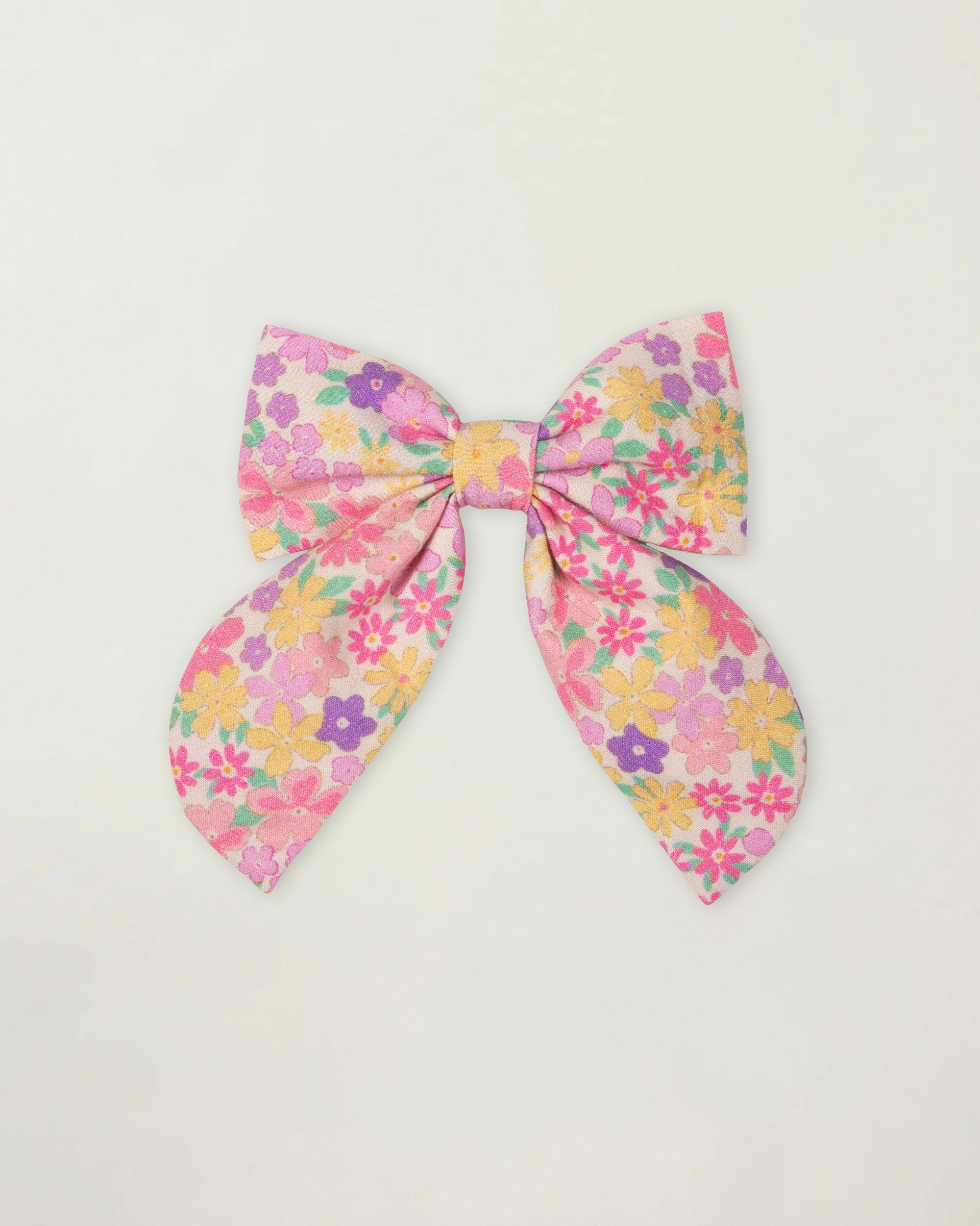 Early Sunday, Audrey Clip in Emma Floral Purple color, made from Organic Printed Cotton Cambric fabric, featuring a fabric bow design with a secure hair clip fastening, shown in a front flat-lay view