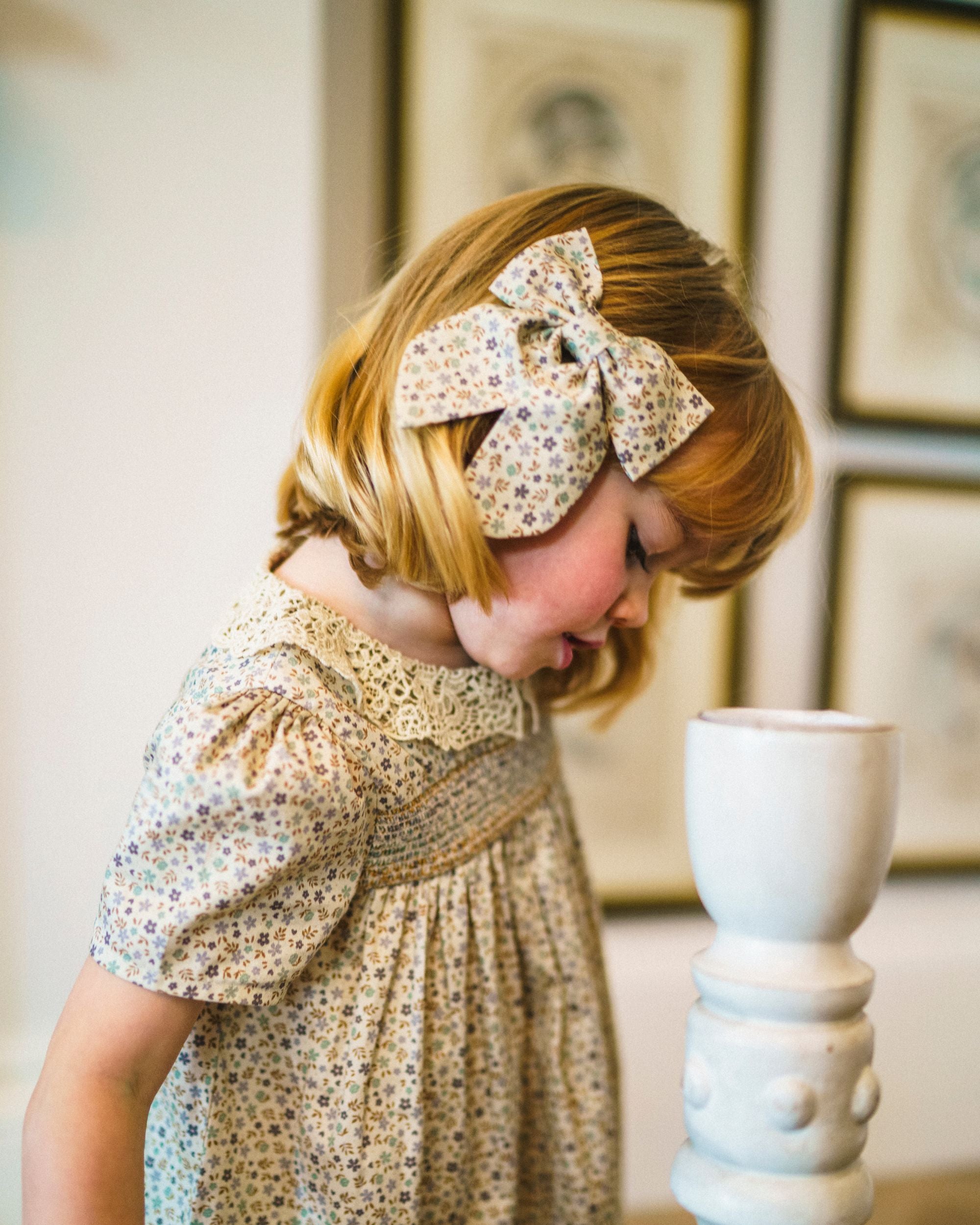Early Sunday, Audrey Clip in Mini Flowers print, made from Printed 60s Cotton Satin fabric, featuring a fabric bow design with a secure hair clip fastening, shown in a side view of a model wearing it