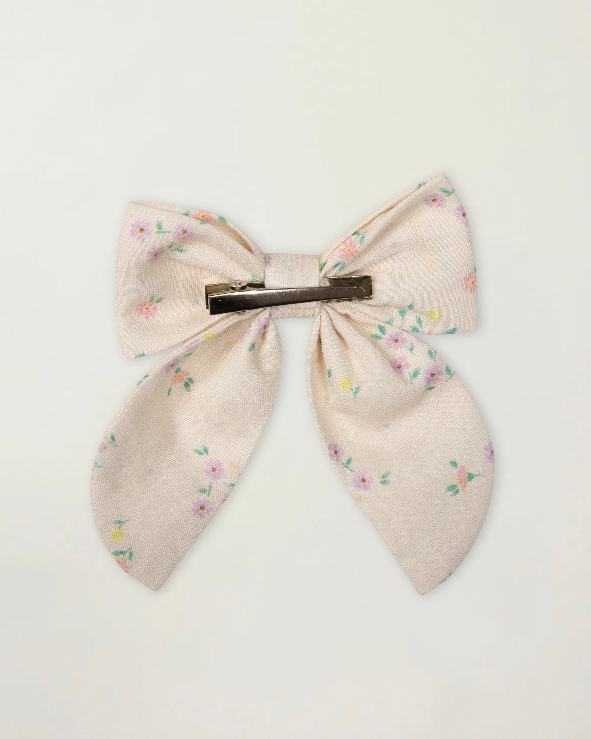 Early Sunday, Audrey Clip in Painted Bouquet print, made from Printed 70% Cotton, 30% Linen fabric, featuring a fabric bow design with a secure hair clip fastening, shown in a back flat-lay view
