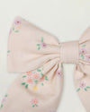 Early Sunday, Audrey Clip in Painted Bouquet print, made from Printed 70% Cotton, 30% Linen fabric, featuring a fabric bow design with a secure hair clip fastening, shown in a closeup flat-lay view