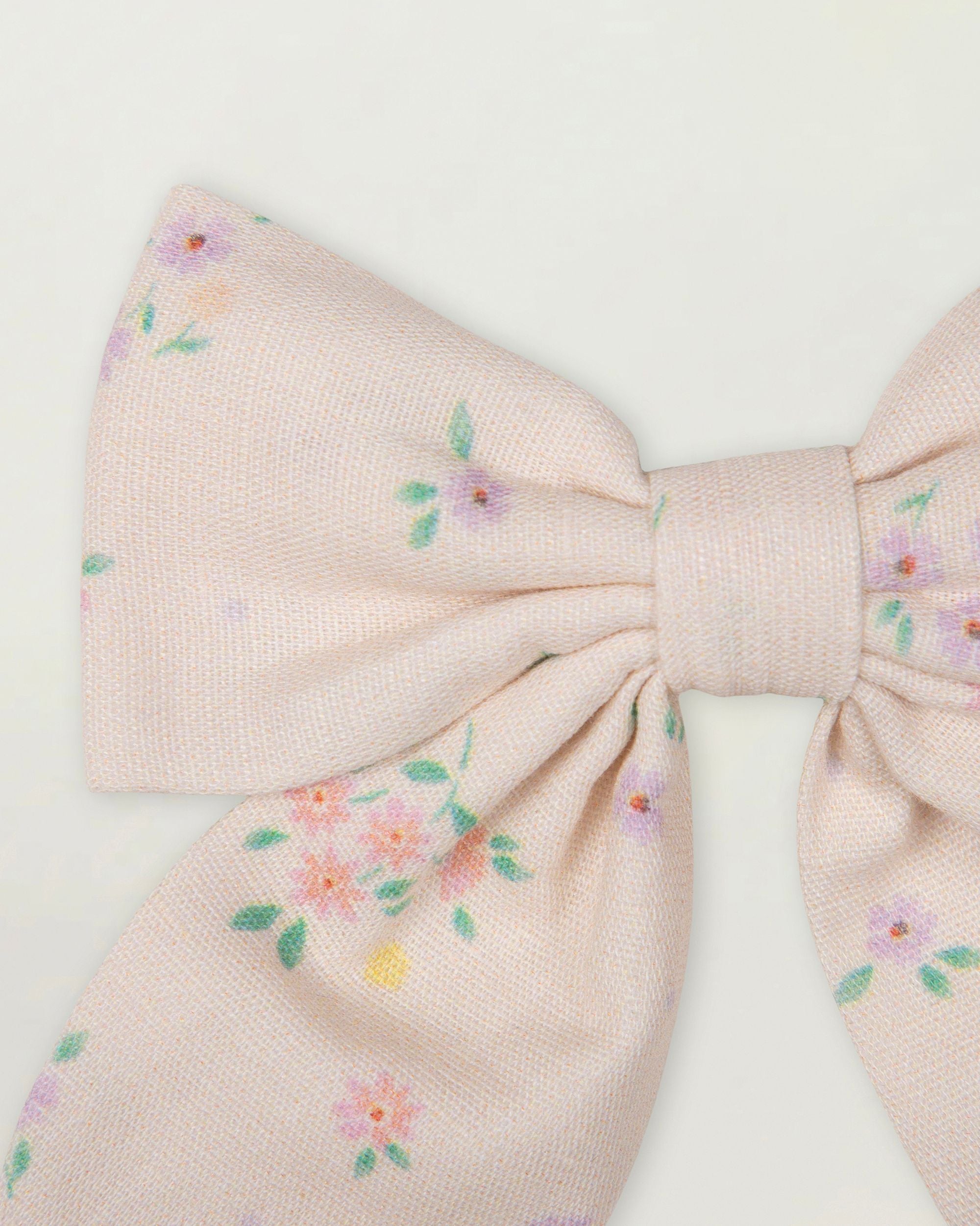 Early Sunday, Audrey Clip in Painted Bouquet print, made from Printed 70% Cotton, 30% Linen fabric, featuring a fabric bow design with a secure hair clip fastening, shown in a closeup flat-lay view