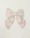 Early Sunday, Audrey Clip in Painted Bouquet print, made from Printed 70% Cotton, 30% Linen fabric, featuring a fabric bow design with a secure hair clip fastening, shown in a front flat-lay view