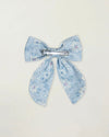 Early Sunday, Audrey Clip in Tonal Floral Blue color, made from Printed 70% Cotton, 30% Linen fabric, featuring a fabric bow design with a secure hair clip fastening, shown in a back flat-lay view