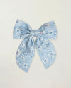 Early Sunday, Audrey Clip in Tonal Floral Blue color, made from Printed 70% Cotton, 30% Linen fabric, featuring a fabric bow design with a secure hair clip fastening, shown in a front flat-lay view