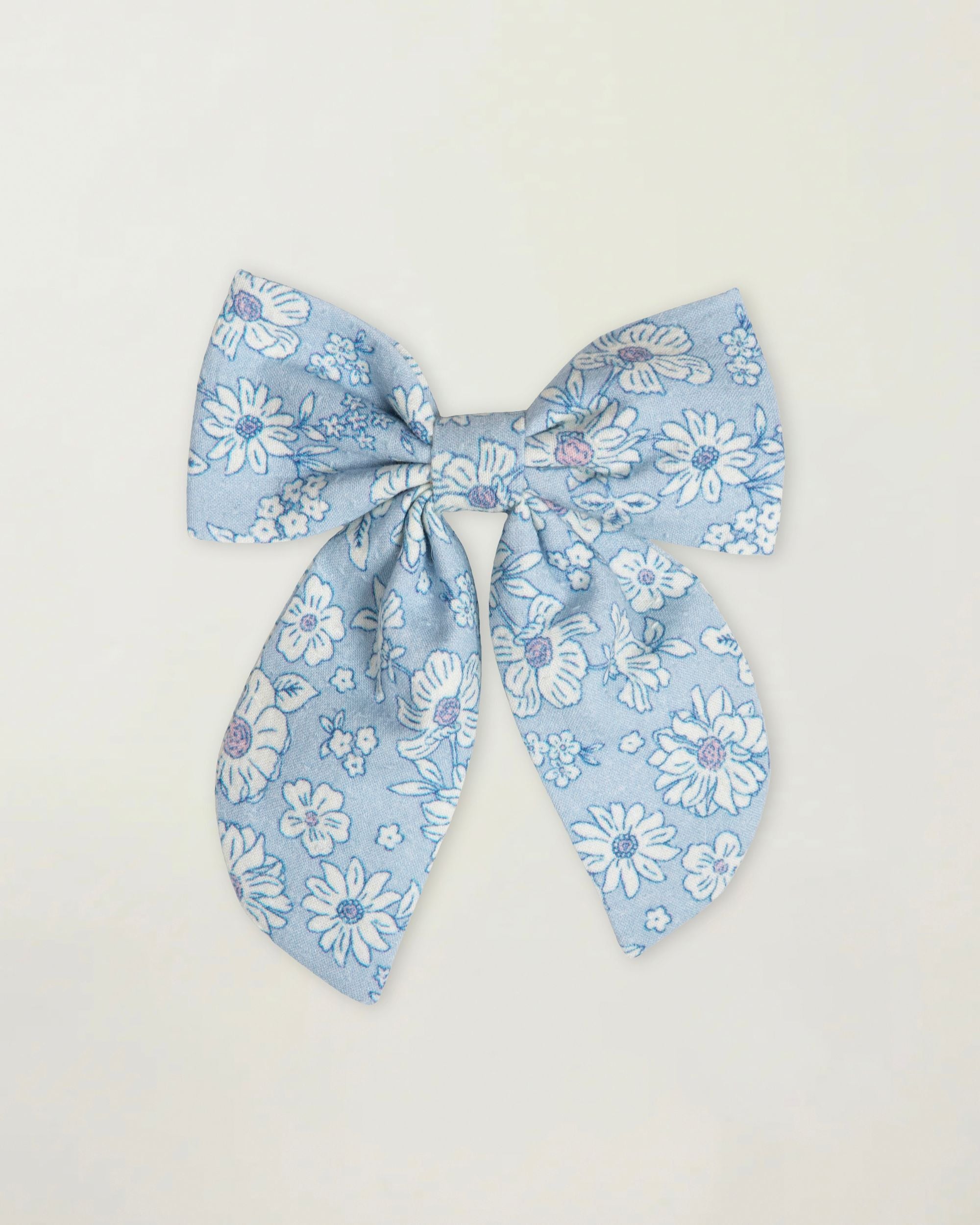 Early Sunday, Audrey Clip in Tonal Floral Blue color, made from Printed 70% Cotton, 30% Linen fabric, featuring a fabric bow design with a secure hair clip fastening, shown in a front flat-lay view