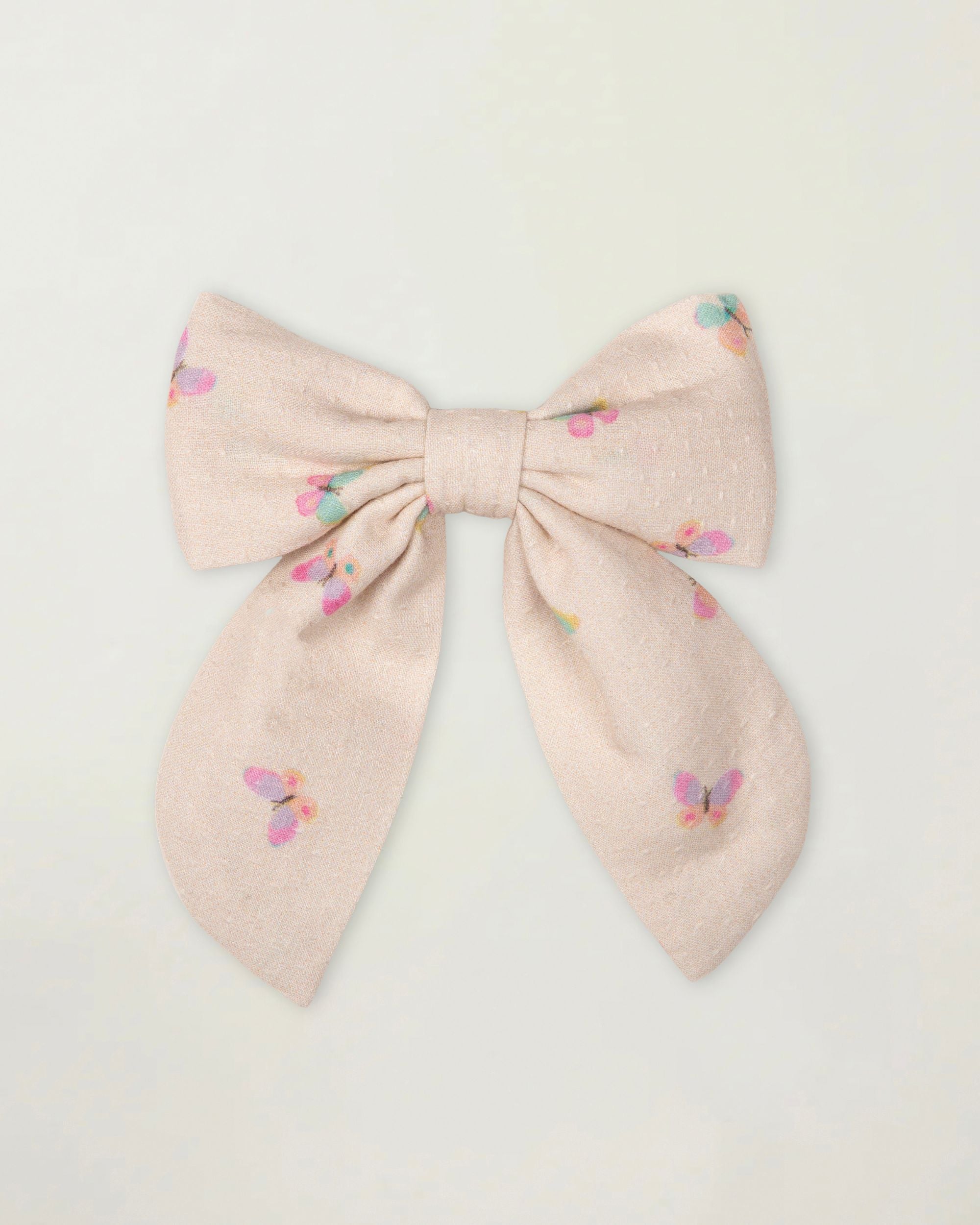 Early Sunday, Audrey Clip in Butterflies print, made from Printed Cotton Tiny Swiss Dobby fabric, featuring a fabric bow design with a secure hair clip fastening, shown in a front flat-lay view