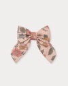 Early Sunday, Audrey Clip in Bloom Blush, made from Printed Viscose Twill fabric, featuring a fabric bow design with a secure hair clip fastening, shown in a front flat-lay view
