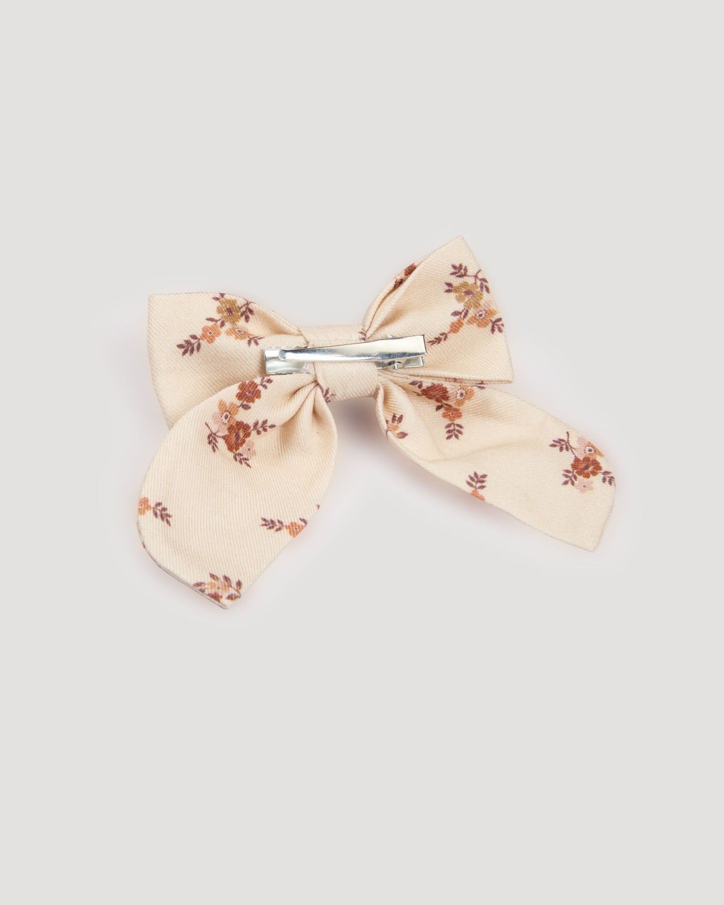 Early Sunday, Audrey Clip in Ditsy Bouquet Cream print, made from Printed Viscose Twill fabric, featuring a fabric bow design with a secure hair clip fastening, shown in a back flat-lay view