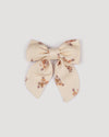 Early Sunday, Audrey Clip in Ditsy Bouquet Cream print, made from Printed Viscose Twill fabric, featuring a fabric bow design with a secure hair clip fastening, shown in a front flat-lay view