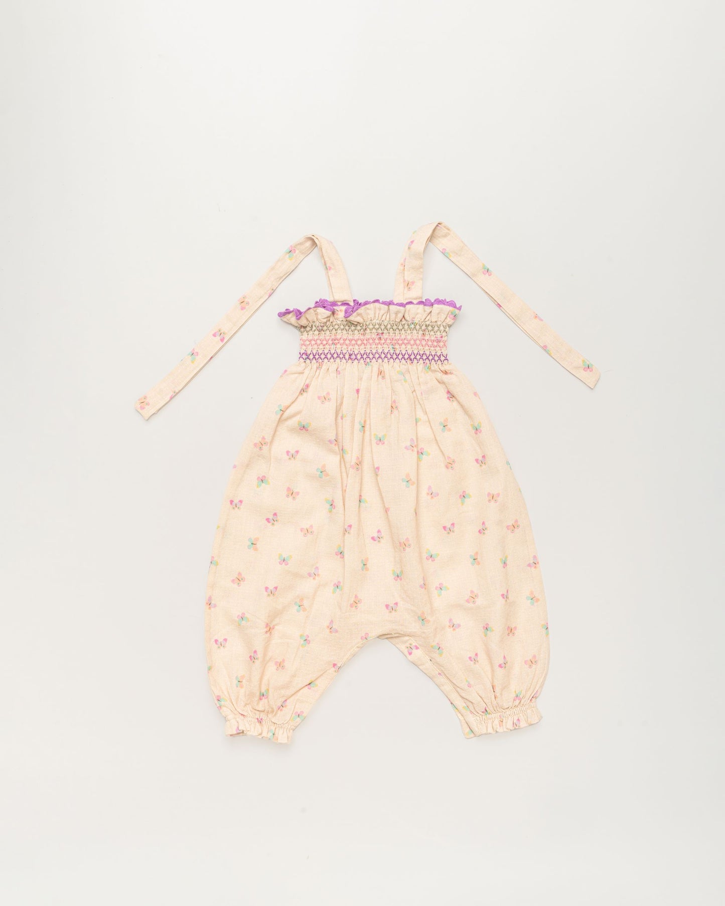 Early Sunday, Audrey Overall Baby Romper in Butterflies print, made from 100% Cotton Swiss Dobby Tiny Dots fabric, featuring tie-up shoulder straps with dot texture & smocked waistband, shown in a front flat-lay view