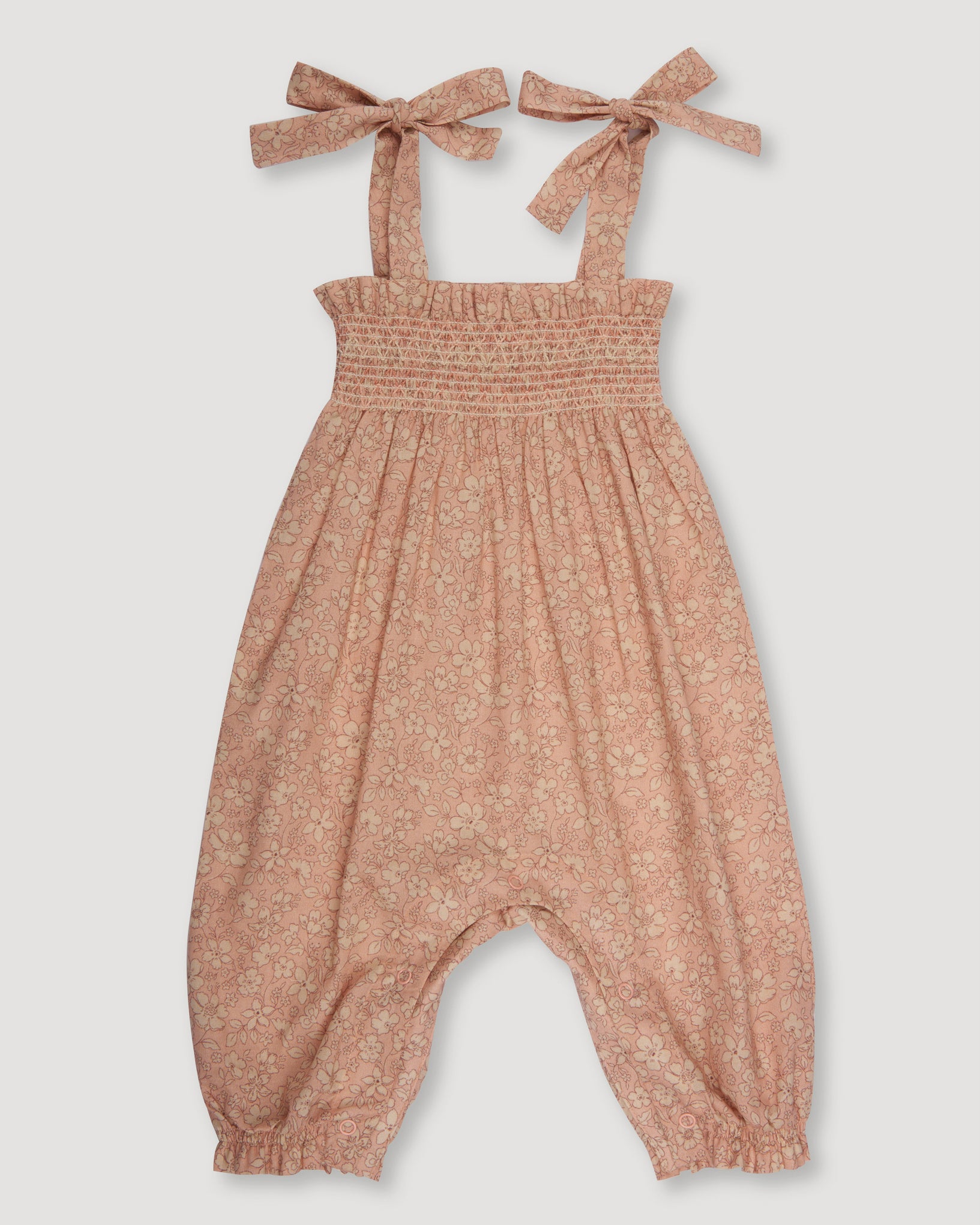 Early Sunday, Audrey Smocked Romper in Garden Flowers print, made from Printed Cotton Cambric fabric, featuring smocked chest and tie up straps, shown in a front flat-lay view