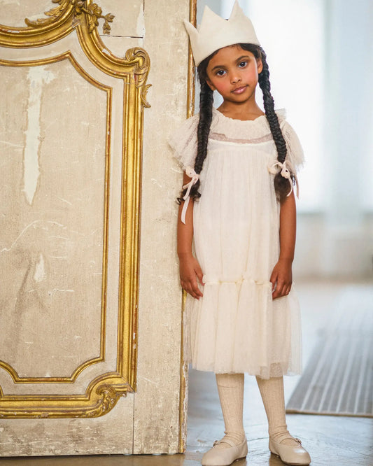 Early Sunday, Aurelia Dress in Hazelnut Cream, made from Dyed Nylon Mesh Dobby fabric, featuring Layered ruffles with flutter sleeves, shown in a front view of model wearing it