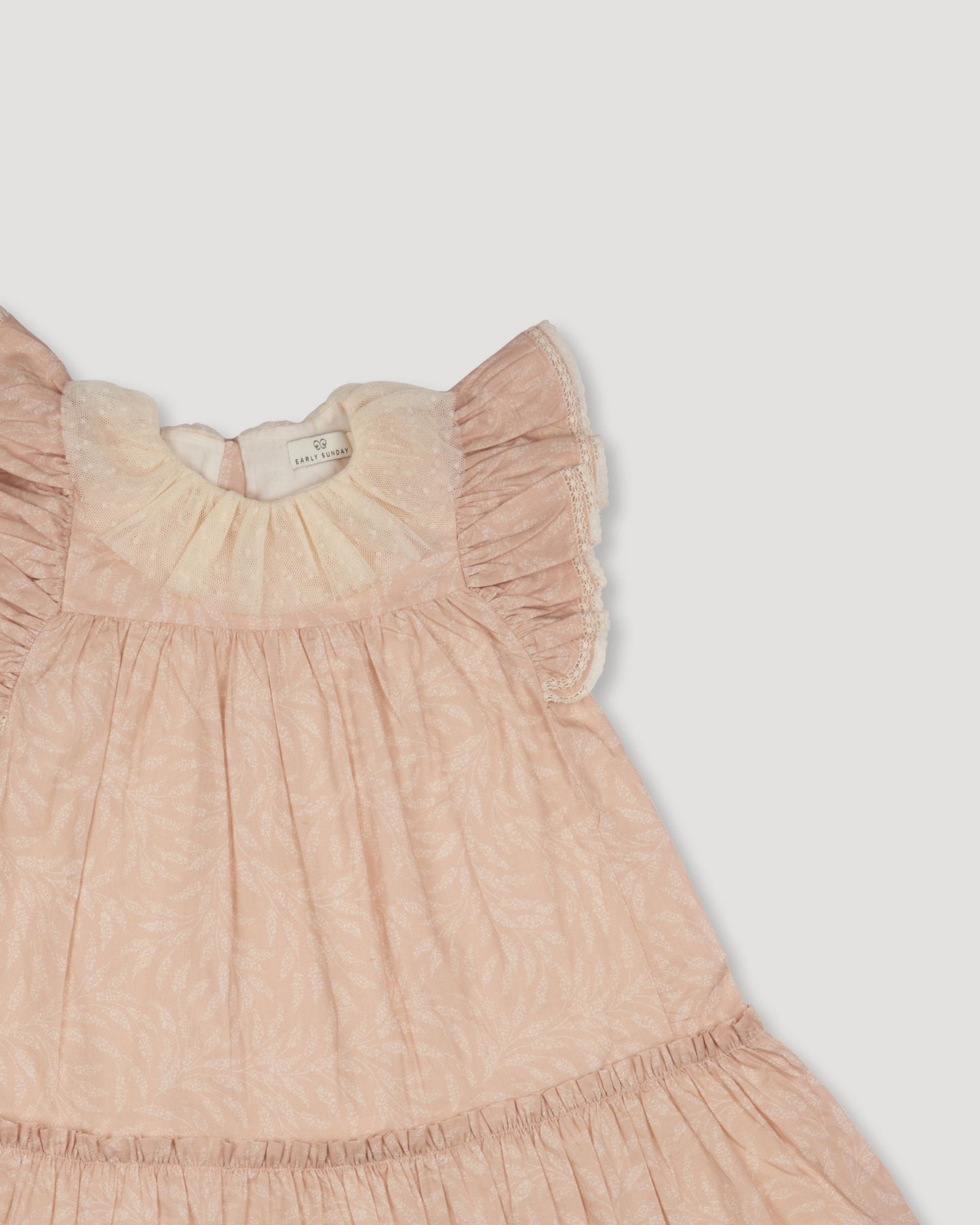 Early Sunday, Aurelia Dress in Feather print, made from Printed Cotton Cambric fabric, featuring Layered ruffles with flutter sleeves, shown in a closeup flat-lay view