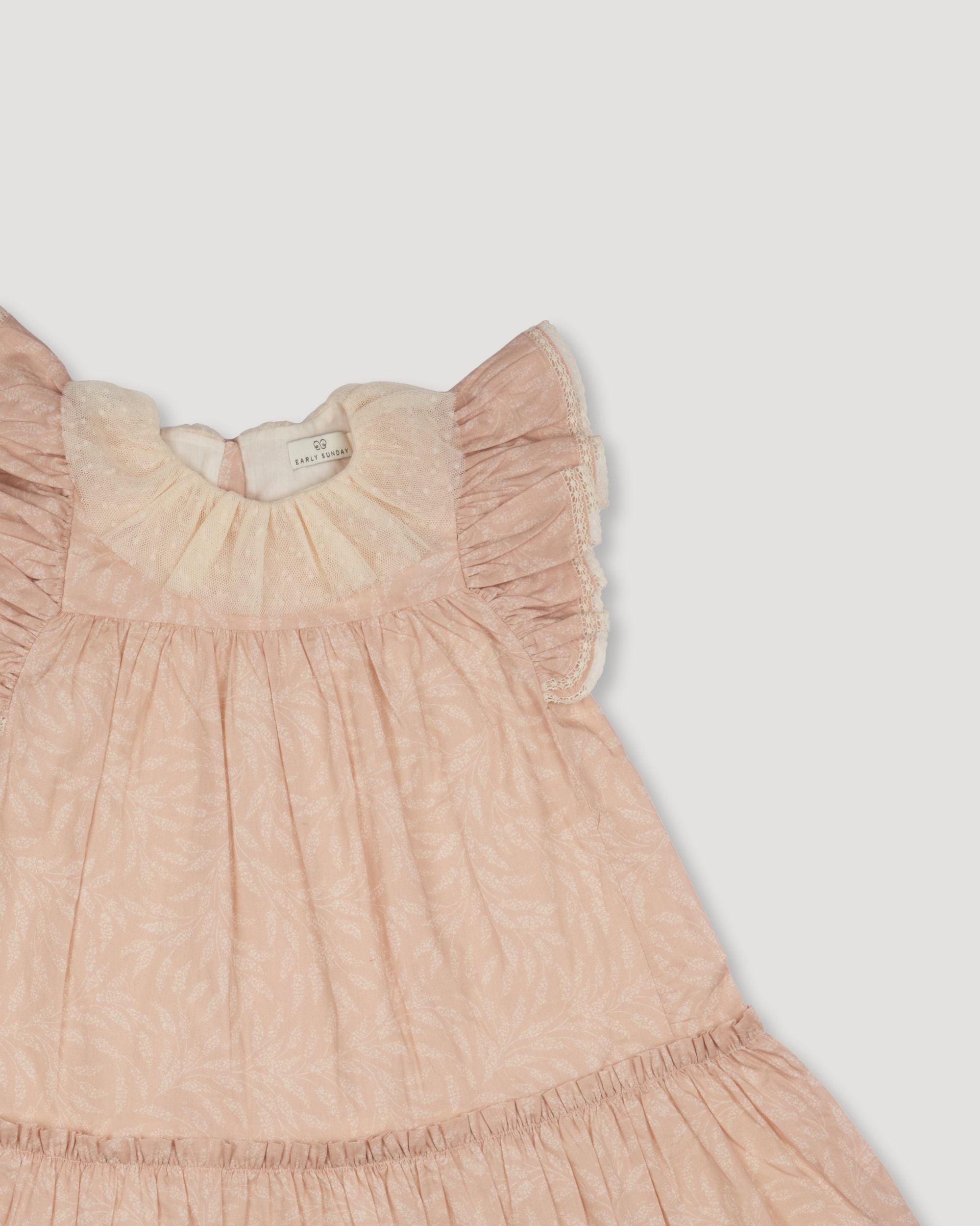 Early Sunday, Aurelia Dress in Feather print, made from Printed Cotton Cambric fabric, featuring Layered ruffles with flutter sleeves, shown in a closeup flat-lay view