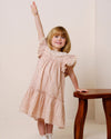 Early Sunday, Aurelia Dress in Feather print, made from Printed Cotton Cambric fabric, featuring Layered ruffles with flutter sleeves, shown in a front view of model wearing it