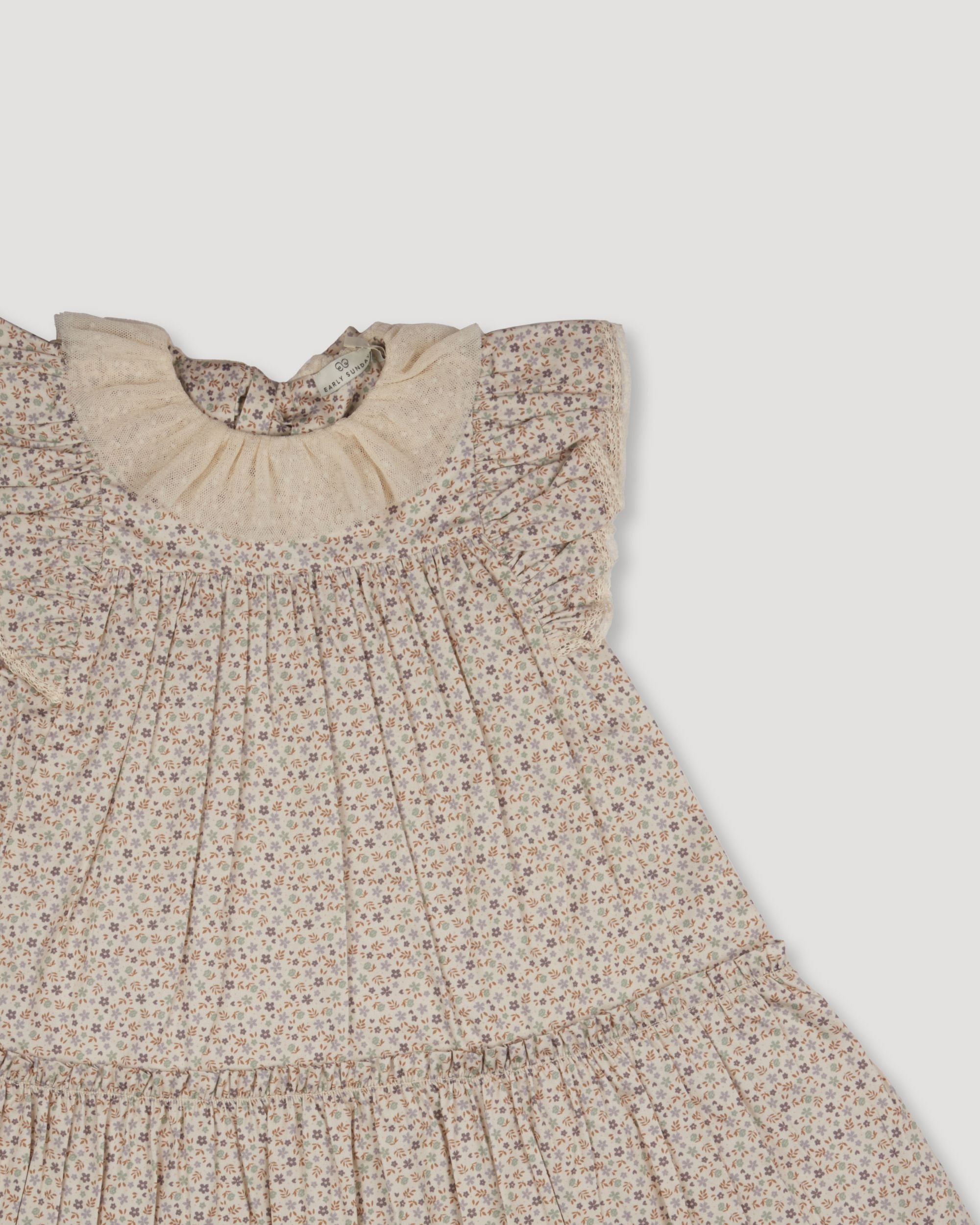 Early Sunday, Aurelia Dress in Miny Flowers print, made from Printed Cotton Satin fabric, featuring Layered ruffles with flutter sleeves, shown in a closeup flat-lay view