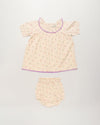 Early Sunday, Baby Bella Dress with Bloomer in Butterflies print, made from 100% Cotton Swiss Dobby Tiny Dots fabric, featuring short puff sleeves with a lilac lace & matching bloomers, shown in a front flat-lay view