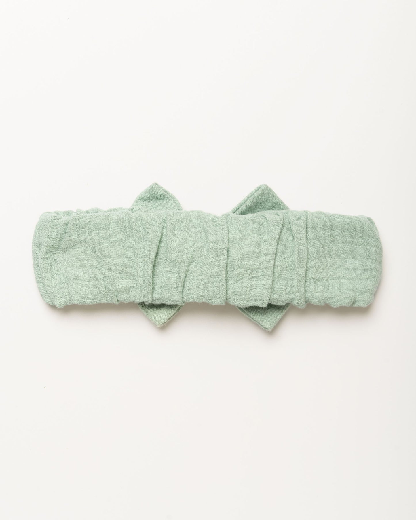 Early Sunday, Baby's Bow Headband in Mint color, made from Cotton Double Gauze fabric, featuring a wide bow design, shown in a back flat-lay view