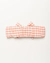 Early Sunday, Baby's Bow Headband in Peony color, made from Gingham Check fabric, featuring a wide bow design, shown in a back flat-lay view