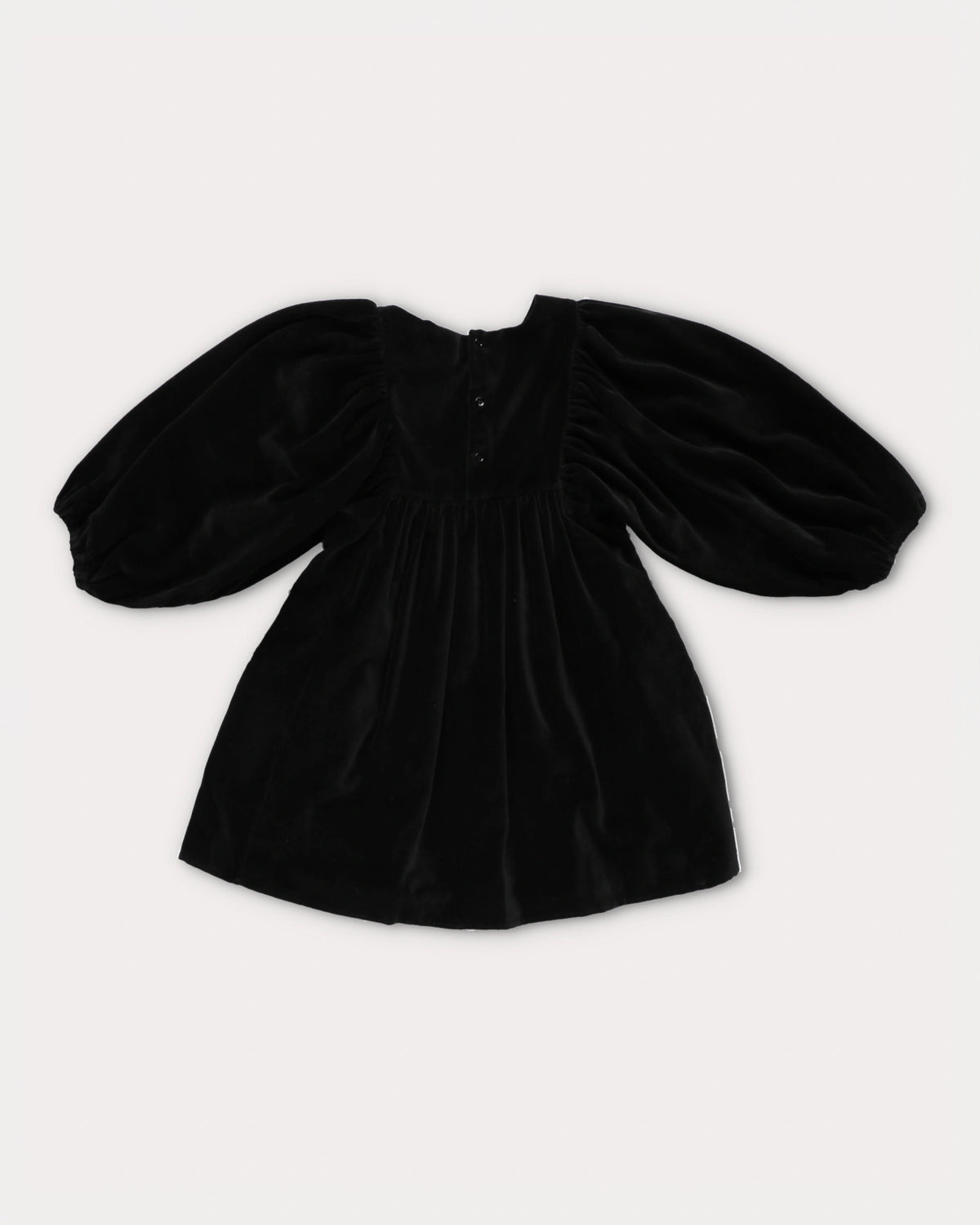 Early Sunday, Belle Dress in Black, made from Cotton Velvet Velour's fabric, featuring a flowing silhouette with puff sleeves and gentle gathers, shown in a back flat-lay view