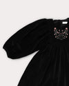 Early Sunday, Belle Dress in Black, made from Cotton Velvet Velour's fabric, featuring a flowing silhouette with puff sleeves and gentle gathers, shown in a closeup flat-lay view