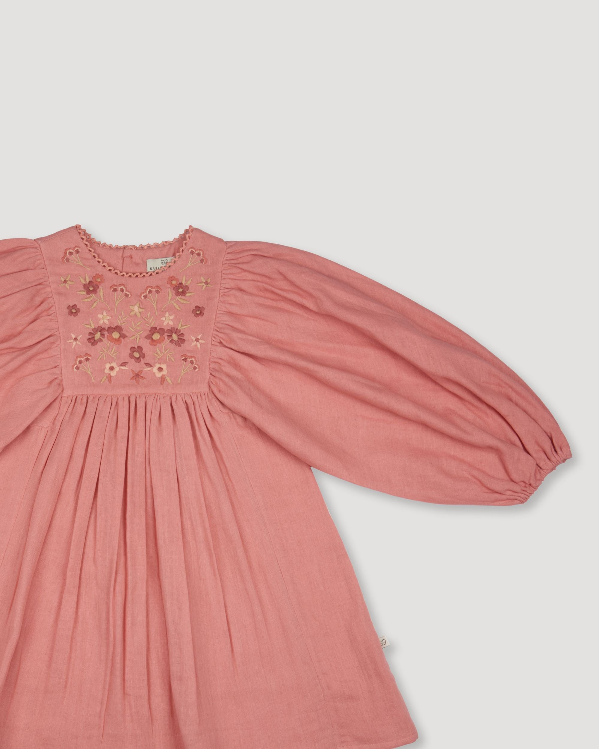 Early Sunday, Belle Dress in Rose, made from Dyed Cotton Double Gauze fabric, featuring Hand-embroidered floral bodice with voluminous puff sleeves for a soft, enchanting silhouette, shown in a closeup flat-lay view