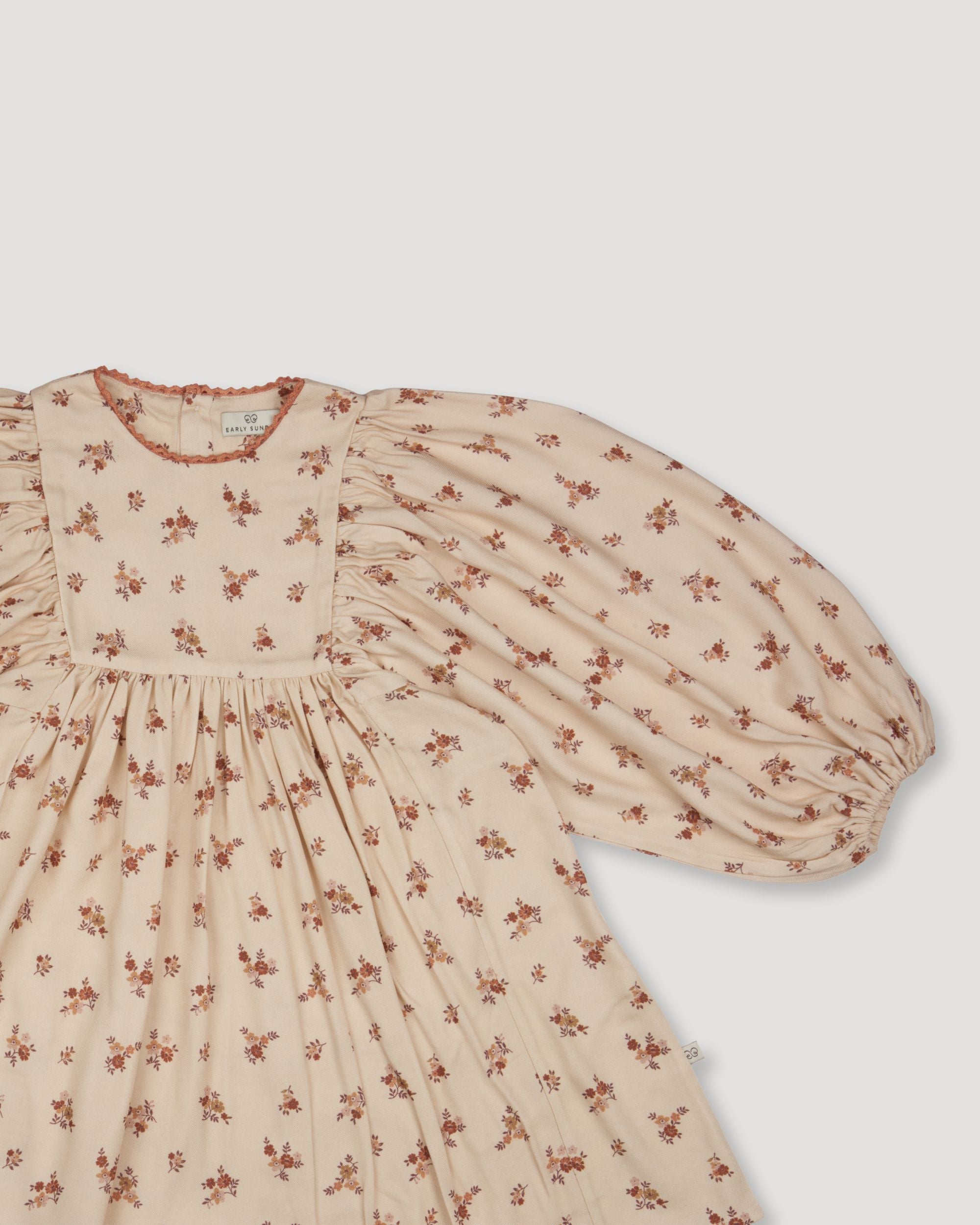 Early Sunday, Belle Dress in Ditsy Bouquet Cream print, made from Printed Viscose Rayon Twill fabric, featuring Hand-embroidered floral bodice with voluminous puff sleeves for a soft, enchanting silhouette, shown in a closeup flat-lay view