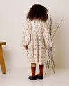Early Sunday, Belle Dress in Ditsy Bouquet Cream print, made from Printed Viscose Rayon Twill fabric, featuring Hand-embroidered floral bodice with voluminous puff sleeves for a soft, enchanting silhouette, shown in a back view of model wearing