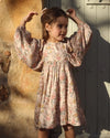 Early Sunday, Belle Dress in Bloom, made from Printed Viscose Twill fabric, featuring a square yoke bodice with puff sleeves and delicate gathered detailing, shown in an angled view of a model wearing outdoors