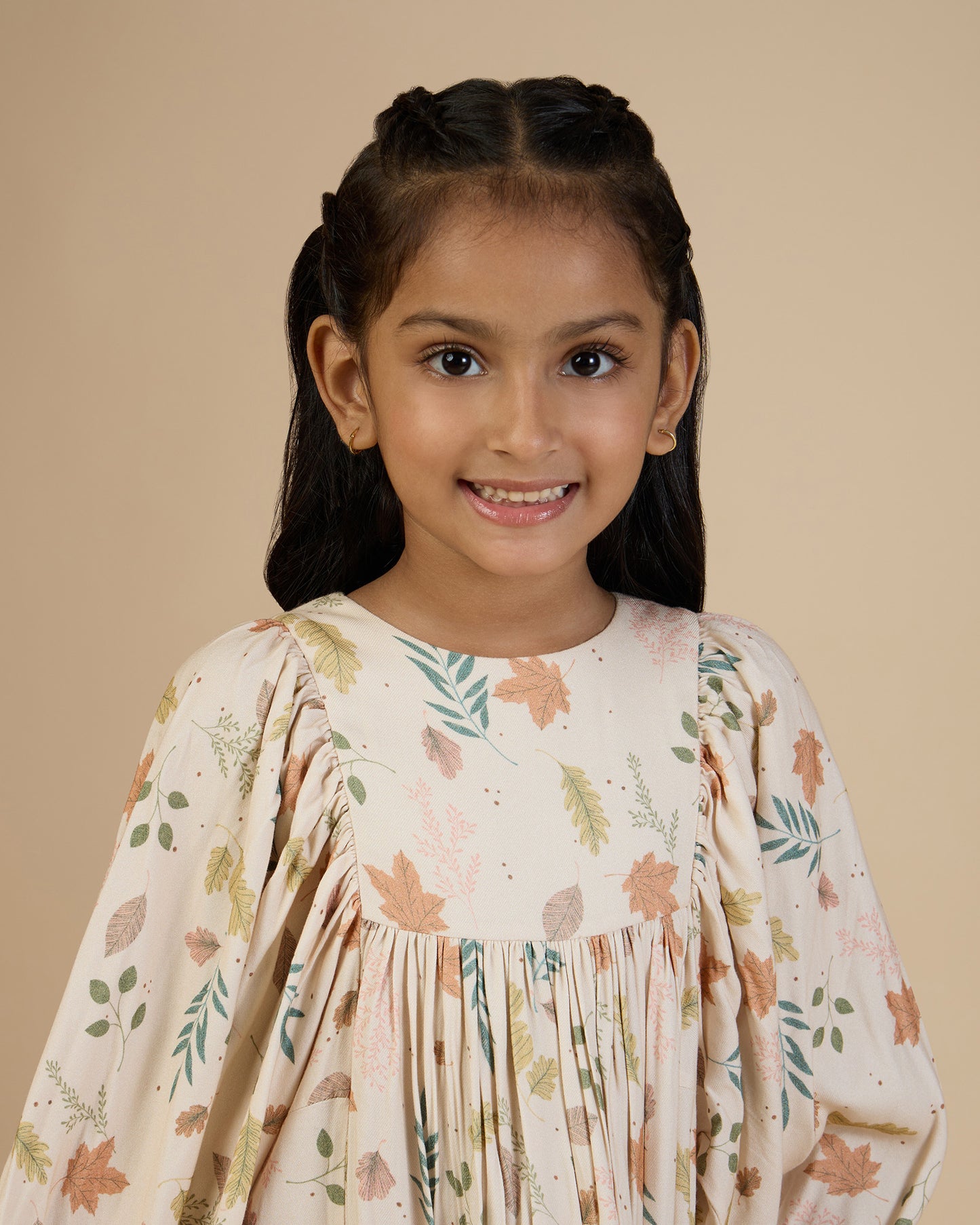 Early Sunday, Belle Dress in Falling Leaves Beige print, made from Printed Viscose Twill fabric, featuring a-line silhouette, bishop sleeves, back button closure, and mid-length, shown in a front view of a model wearing it in a studio setting
