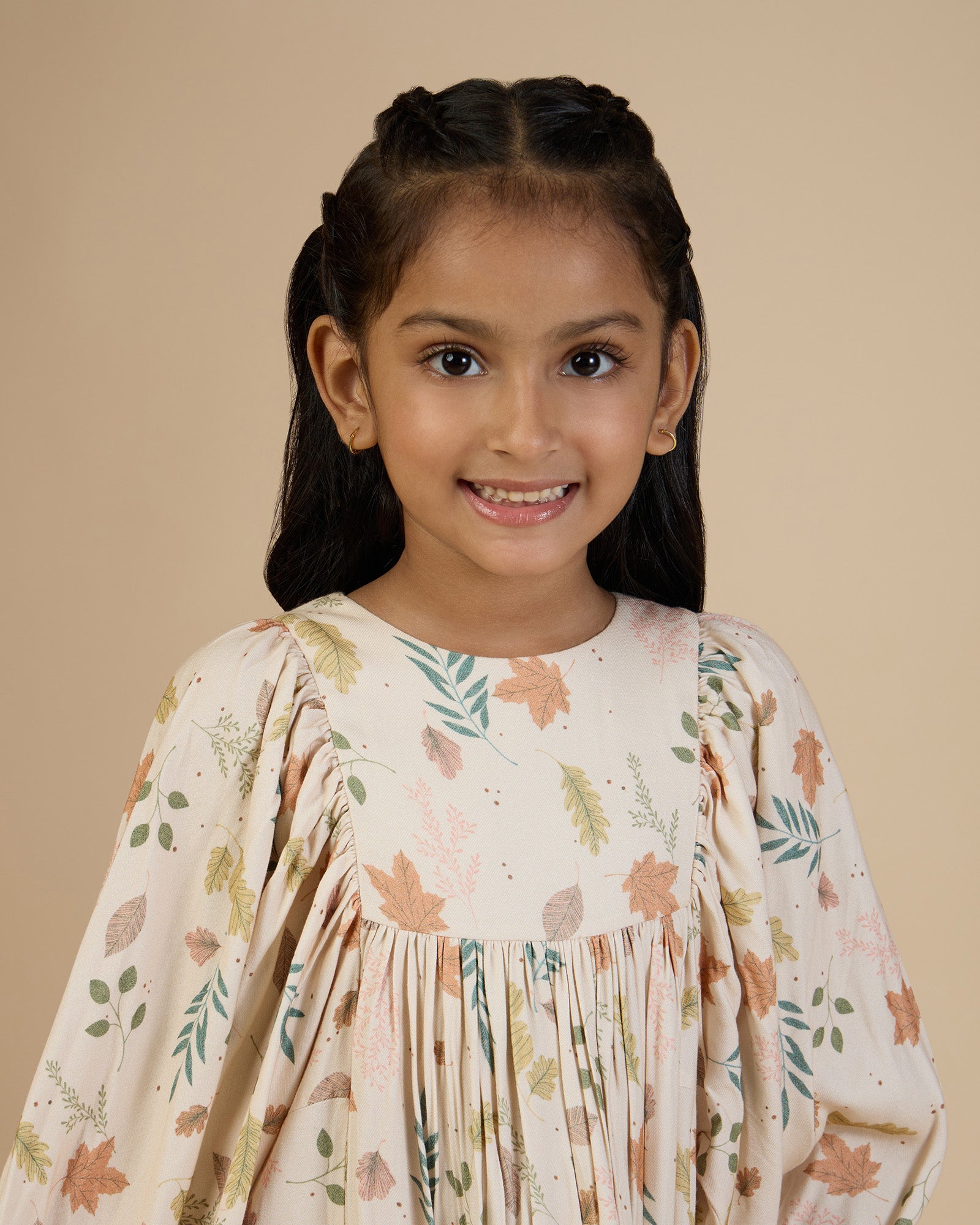 Early Sunday, Belle Dress in Falling Leaves Beige print, made from Printed Viscose Twill fabric, featuring a-line silhouette, bishop sleeves, back button closure, and mid-length, shown in a front view of a model wearing it in a studio setting