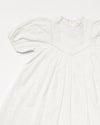 Early Sunday, Beth Dress in Ivory color, made from 100% cotton all over embroidered fabric, featuring Puff sleeves, contrast scalloped collar for a vintage touch, shown in a closeup flat-lay view.