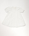 Early Sunday, Beth Dress in Ivory color, made from 100% cotton all over embroidered fabric, featuring Puff sleeves, contrast scalloped collar for a vintage touch, shown in a front flat-lay view.