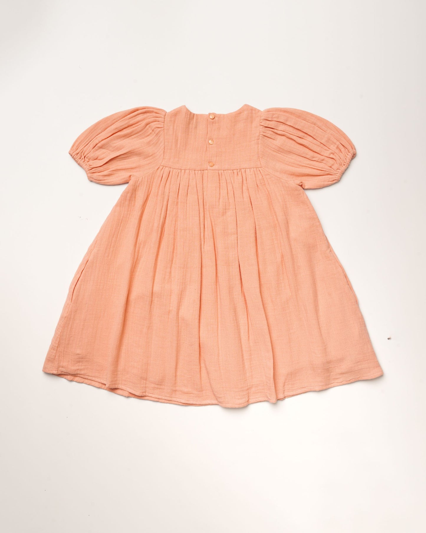 Early Sunday, Beth Dress in Candy Floss color, made from 100% cotton double gauze solid fabric, featuring Puff sleeves, contrast scalloped collar for a vintage touch, shown in a back flat-lay view.