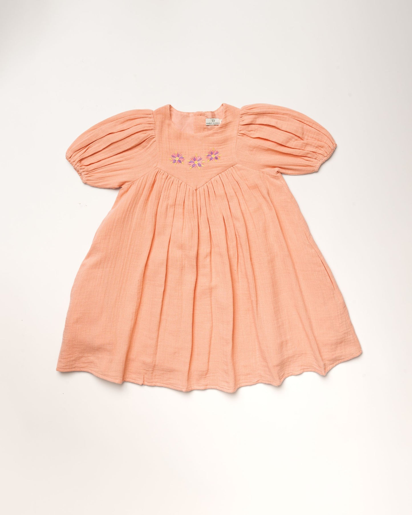 Early Sunday, Beth Dress in Candy Floss color, made from 100% cotton double gauze solid fabric, featuring Puff sleeves, contrast scalloped collar for a vintage touch, shown in a front flat-lay view.