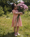 Early Sunday, Beth Dress in Candy Floss color, made from 100% cotton double gauze solid fabric, featuring Puff sleeves, contrast scalloped collar for a vintage touch, shown in a model wearing outdoors.