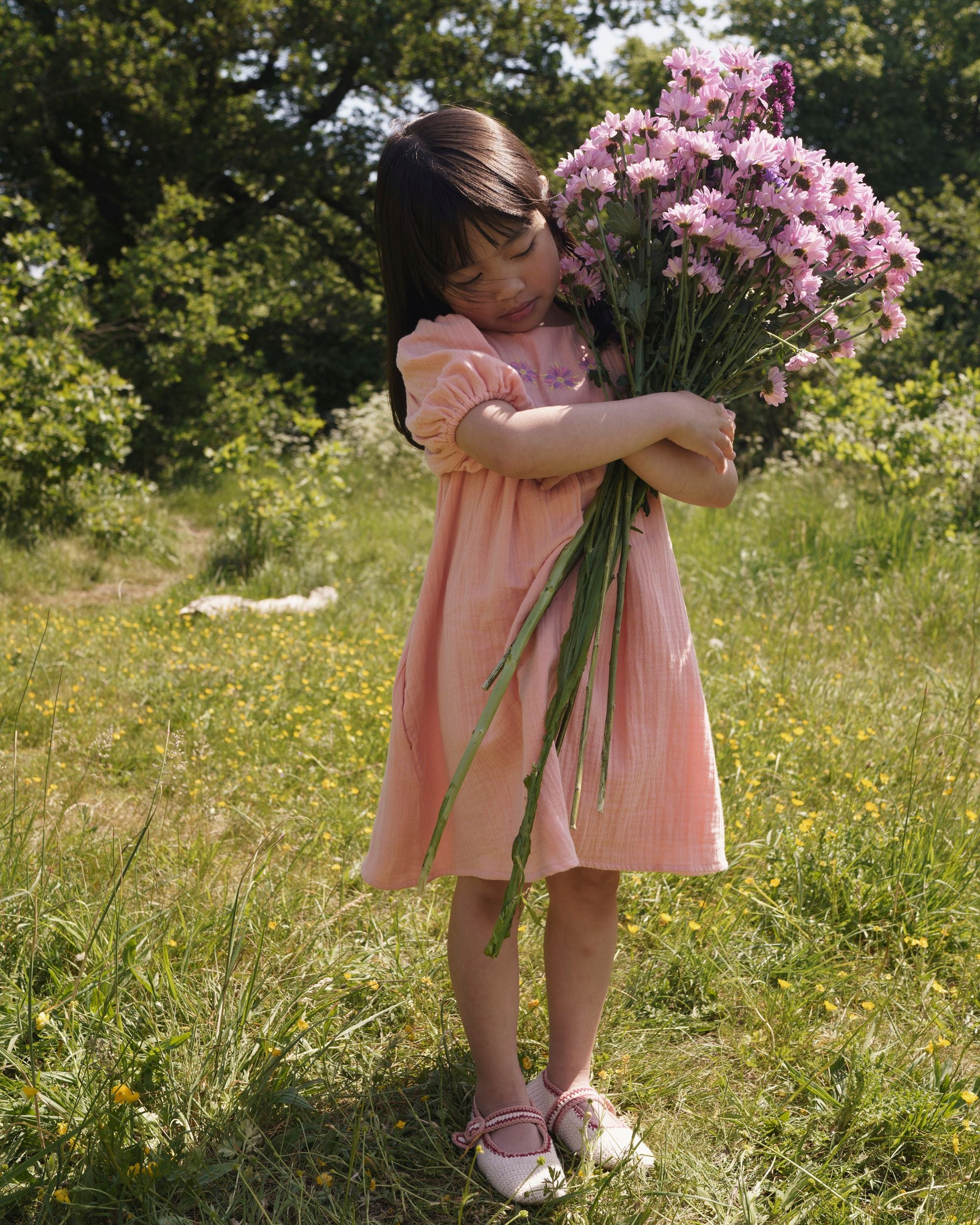 Early Sunday, Beth Dress in Candy Floss color, made from 100% cotton double gauze solid fabric, featuring Puff sleeves, contrast scalloped collar for a vintage touch, shown in a model wearing outdoors.