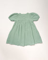 Early Sunday, Beth Dress in Mint color, made from 100% cotton double gauze solid fabric, featuring Puff sleeves, contrast scalloped collar for a vintage touch, shown in a back flat-lay view.