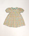 Early Sunday, Beth Dress in Emma Floral Mint color, made from printed cotton cambric fabric, featuring Puff sleeves, contrast scalloped collar for a vintage touch, shown in a back flat-lay view.