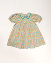 Early Sunday, Beth Dress in Emma Floral Mint color, made from printed cotton cambric fabric, featuring Puff sleeves, contrast scalloped collar for a vintage touch, shown in a front flat-lay view.